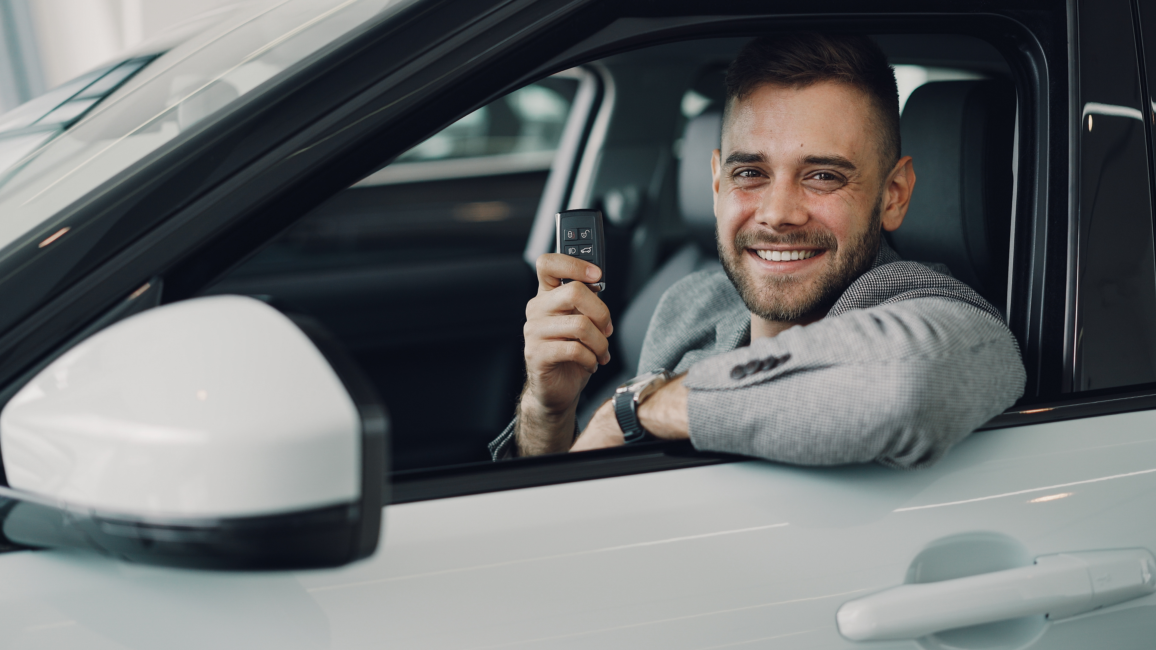 Man-smiling-after-getting-keys-to-new-car